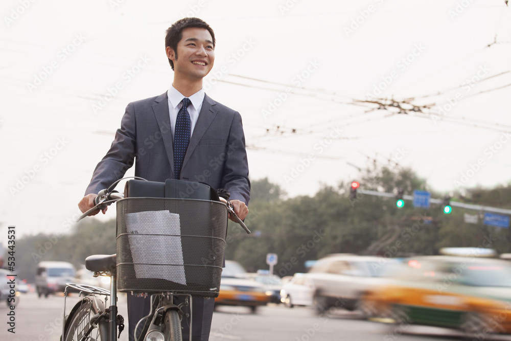 Young businessman riding a bicycle on the street, Beijing