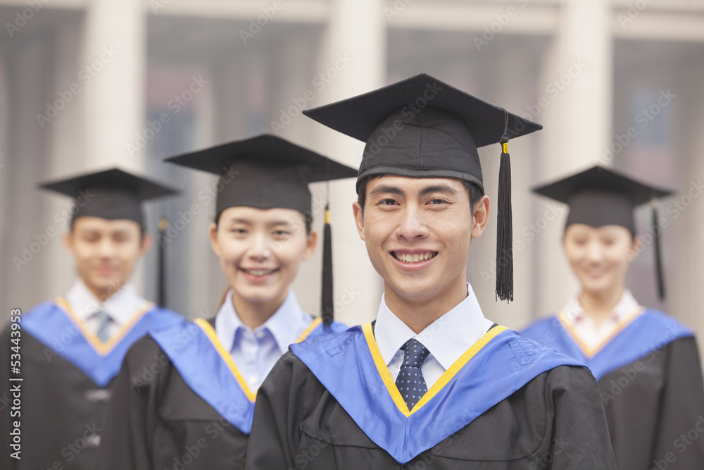 Four University Graduates Smiling, Looking at Camera Four University Graduates Smiling, Looking at Camera