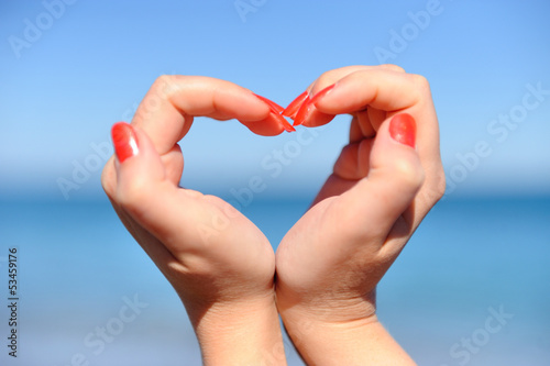Female hand making a heart shape against
