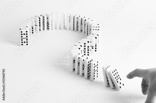 Dominoes in shape of question mark on plain background