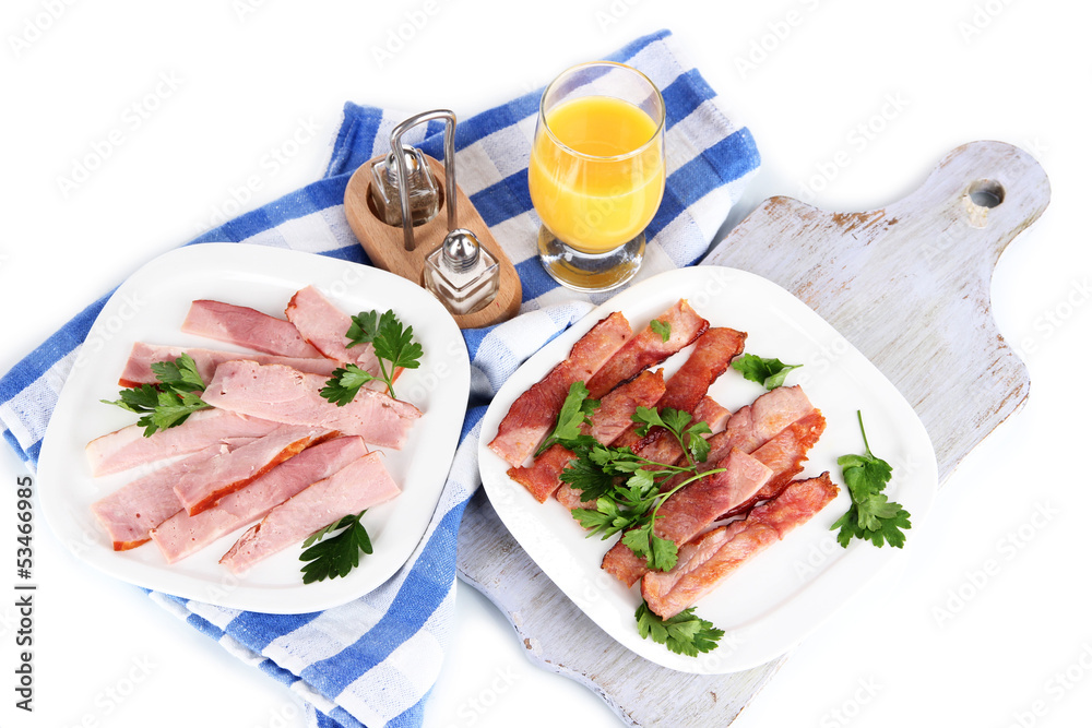Bacon on plates on napkin on board isolated on white Bacon on plates on napkin on board isolated on white
