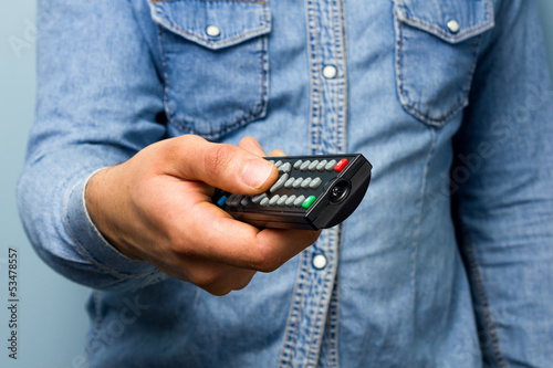 Man changing the channel with remote control