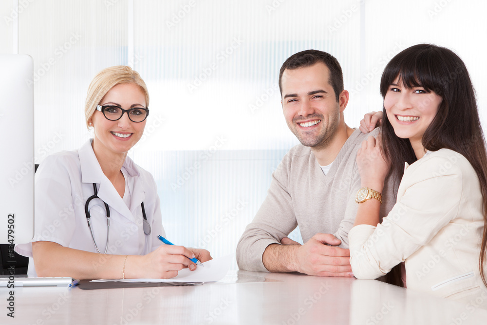 Happy Doctor Discussing With Couple Happy Doctor Discussing With Couple