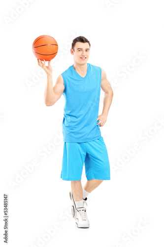 Full length portrait of a basketball player holding a basketball