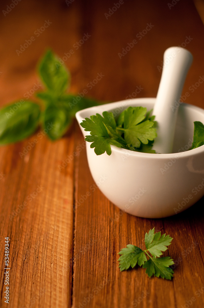 mortar with herbs on a wooden background