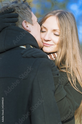 young caucasian couple kissing and standing together photo