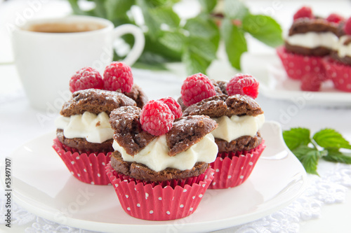 Chocolate muffins with raspberries and cream.