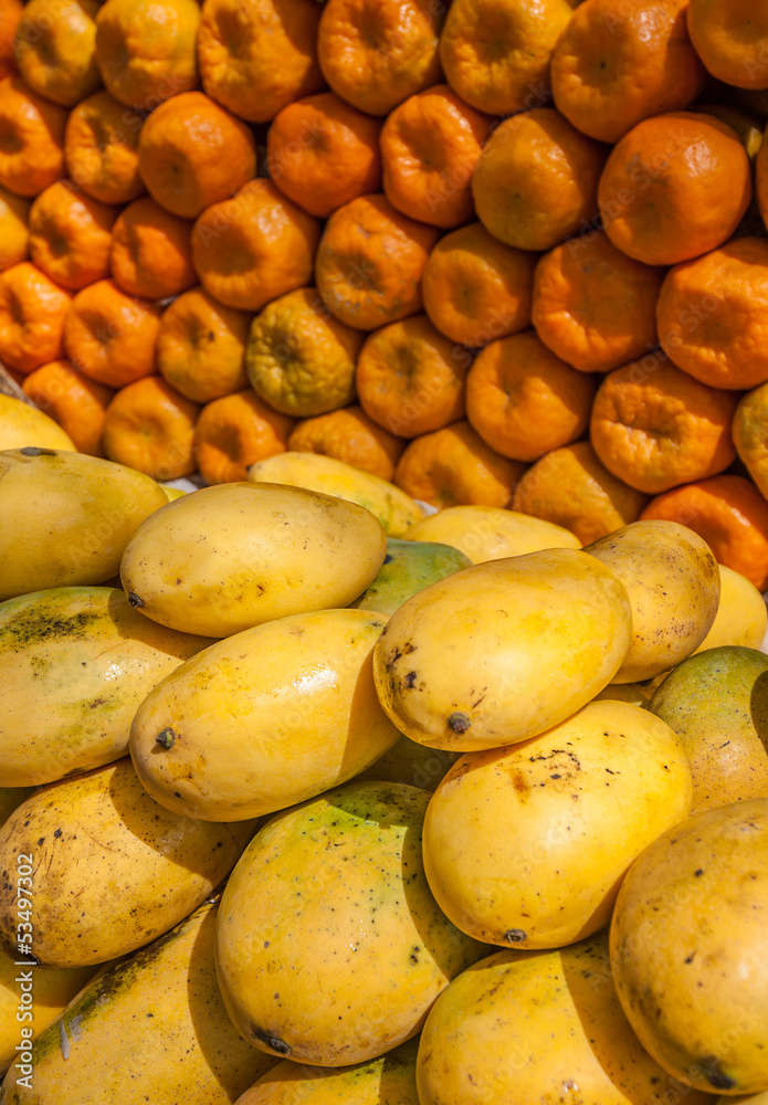 Yellow mangos and tangerines at fruit market Yellow mangos and tangerines at fruit market