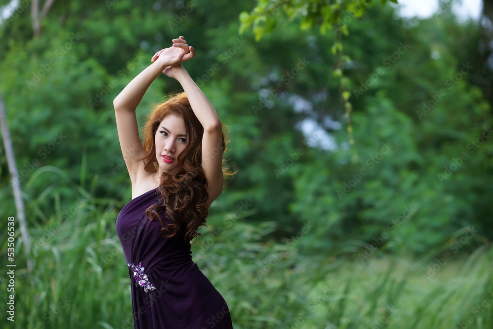 Young Asian woman posing in greenery background Young Asian woman posing in greenery background