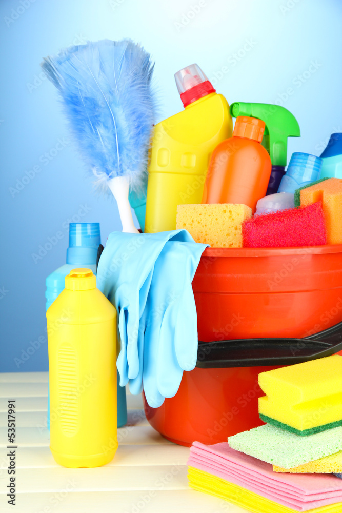 Cleaning items in bucket on color background Cleaning items in bucket on color background