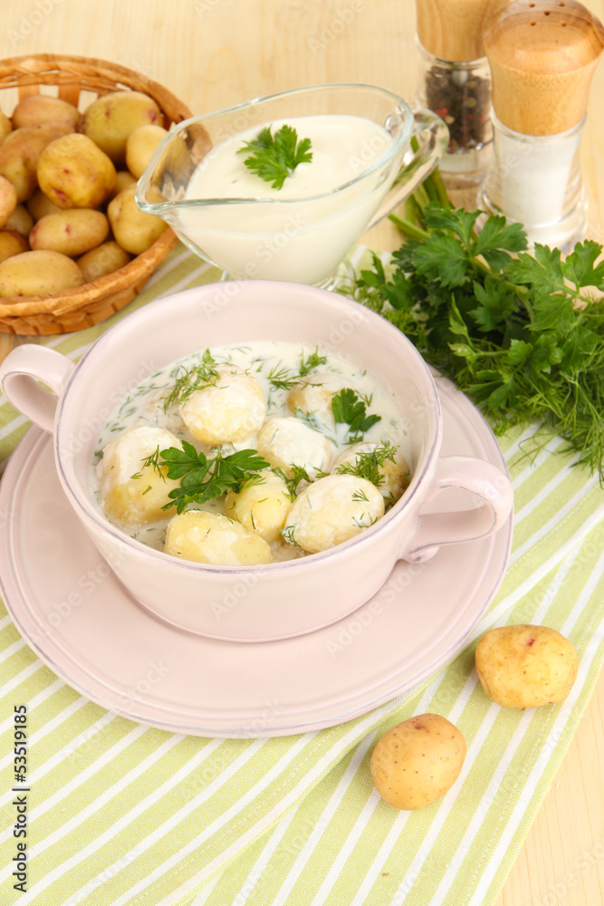 Tender young potatoes with sour cream and herbs in pan Tender young potatoes with sour cream and herbs in pan