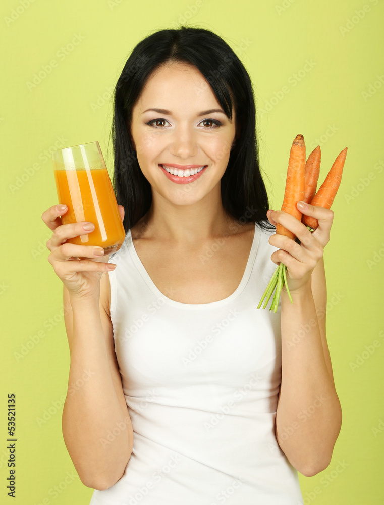 Girl with fresh carrot and juice on green background Girl with fresh carrot and juice on green background