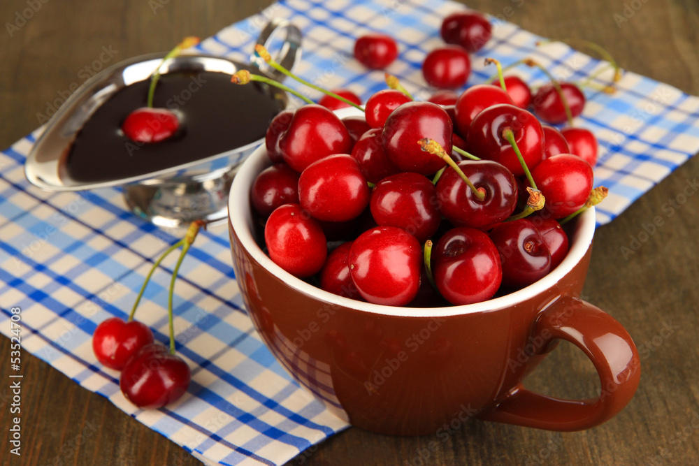Ripe red cherry berries in cup and chocolate sauce Ripe red cherry berries in cup and chocolate sauce