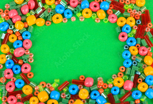Different colorful beads on green background
