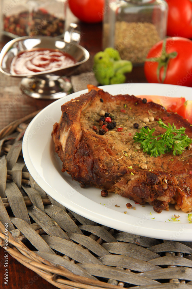 Piece of fried meat on plate on wooden table close-up