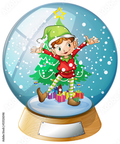 An elf in front of a christmas tree inside a snowball