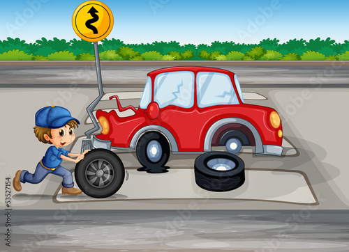 A boy repairing a car near the signage