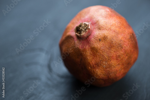 Close-up of a pomegranate on black wooden boards