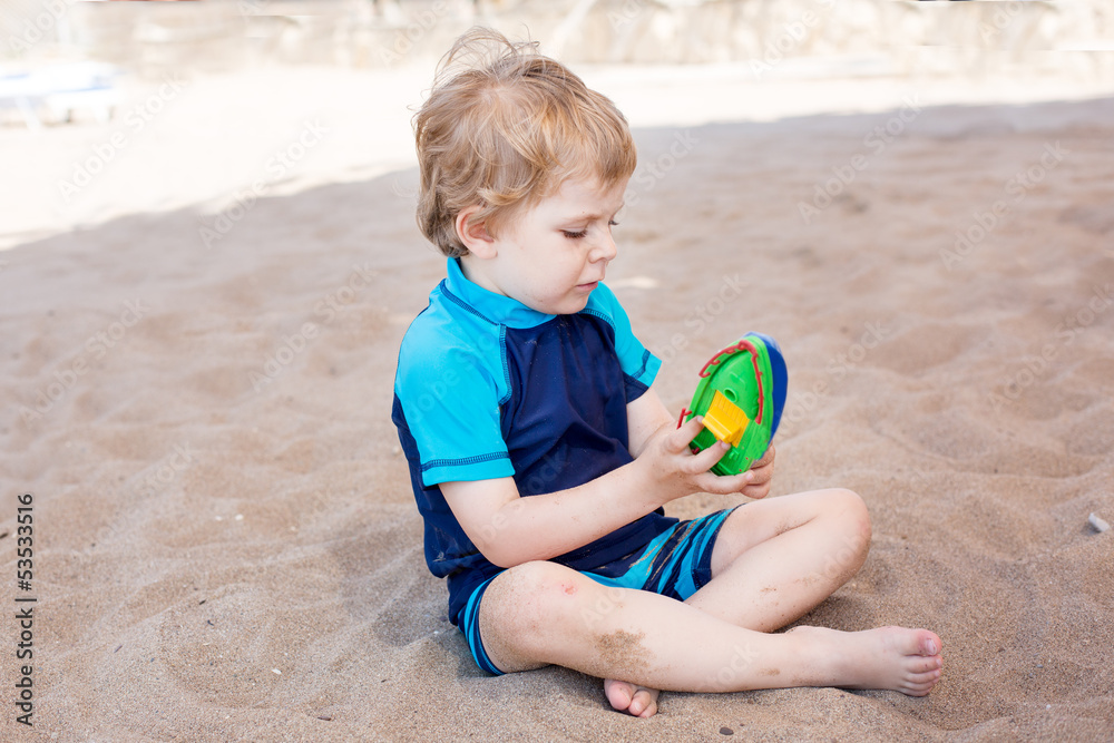 Little toddler boy playing with sand and toy Little toddler boy playing with sand and toy