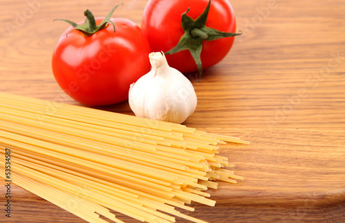 Spaghetti, garlic, tomato, cutting board