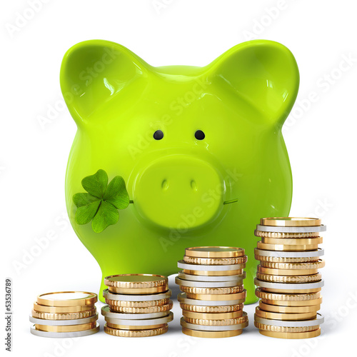 Green piggy bank with clover and coin stacks photo