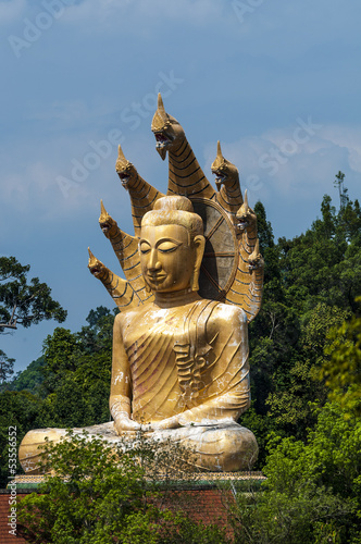 Golden Buddha statue surrounded by mountains