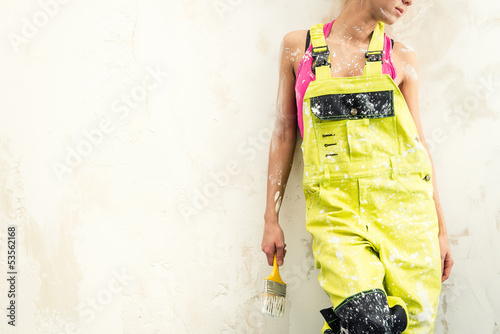 Tablou pe pânză Female in coverall holding paint brush over obsolete background
