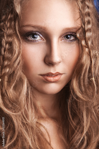 Portrait of charming young woman with curly brown hair