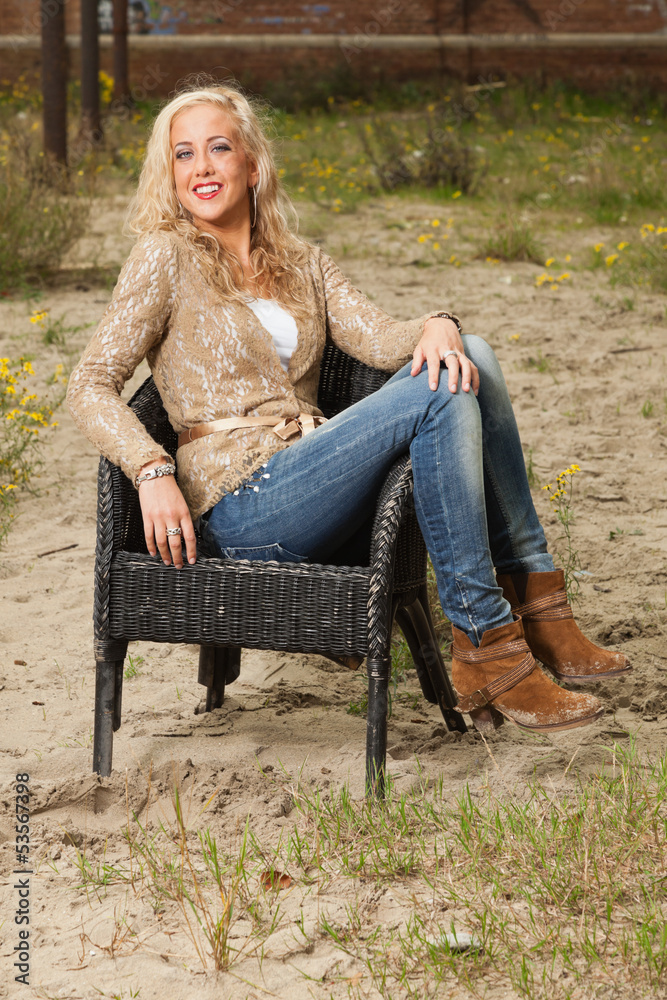Pretty blonde fashion girl sitting in chair outdoor in urban env Pretty blonde fashion girl sitting in chair outdoor in urban env
