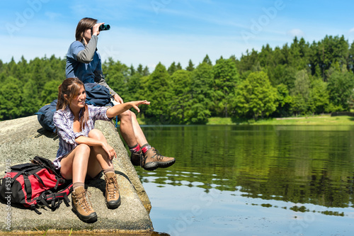 Teenage hikers birdwatching at lake