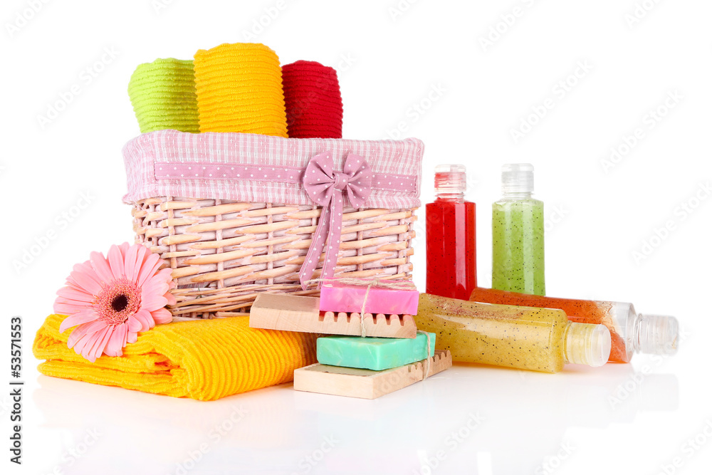 Colorful towels in basket, cosmetics bottles and soap, isolated Colorful towels in basket, cosmetics bottles and soap, isolated