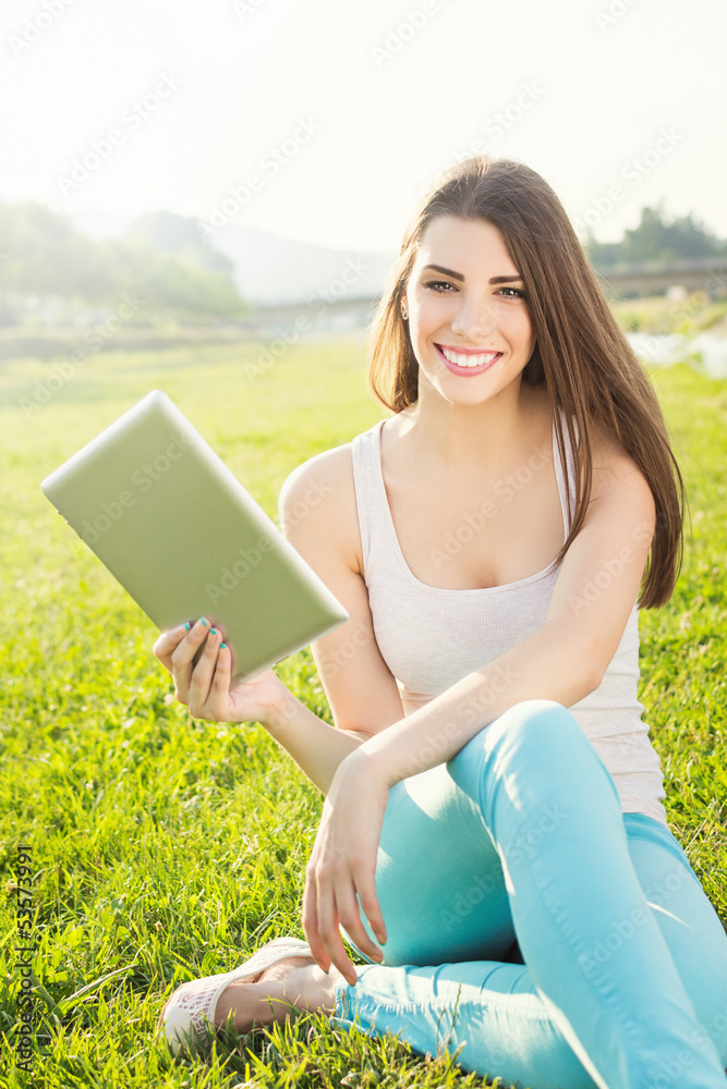 Attractive student in nature holding digital tablet Attractive student in nature holding digital tablet