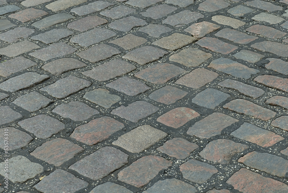 Fototapeta premium Old cobbled stone road running diagonally.