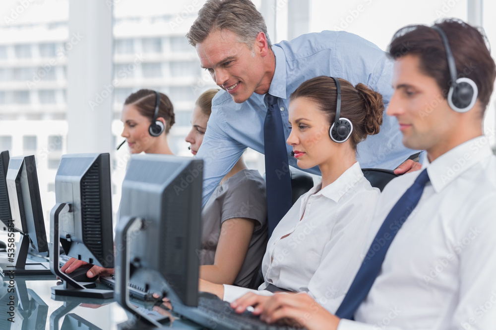 Naklejka premium Smiling manager helping call centre agent