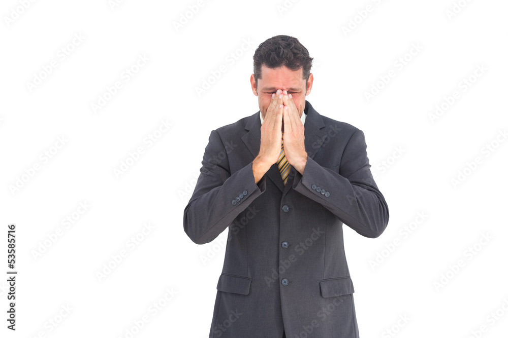 Troubled businessman with hands on his face Troubled businessman with hands on his face
