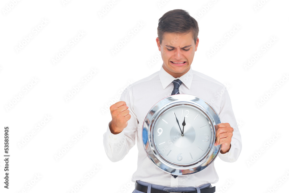 Anxious businessman holding and looking at clock Anxious businessman holding and looking at clock