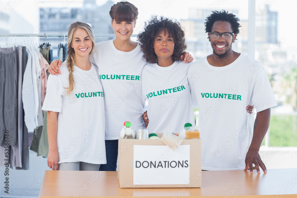 Volunteers standing in front of food in a donation box Volunteers standing in front of food in a donation box