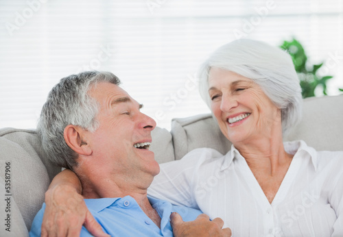 Couple laughing and chatting on a couch