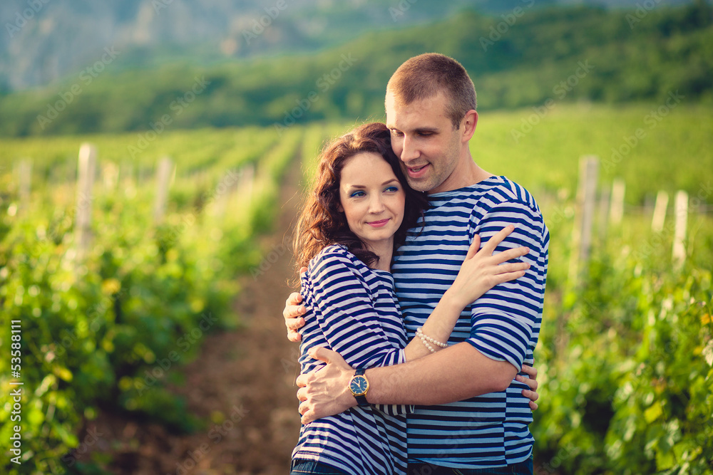 Fototapeta premium Couple in striped shirts in the vineyard