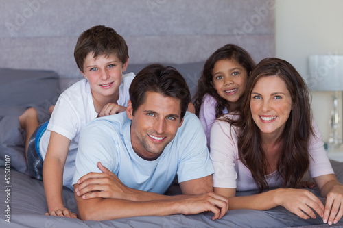 Happy family lying on bed