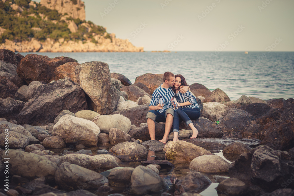 Family in striped shirts on the rocks near the sea