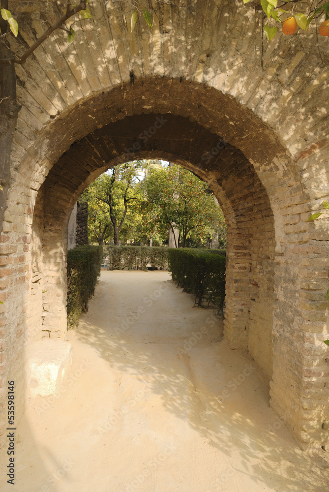 Brick arch in the gardens of the Alcazar of Seville, Spain