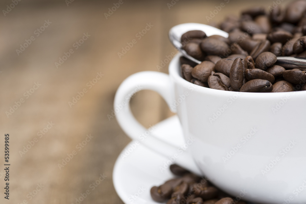 Cup of coffee and beans on wooden background