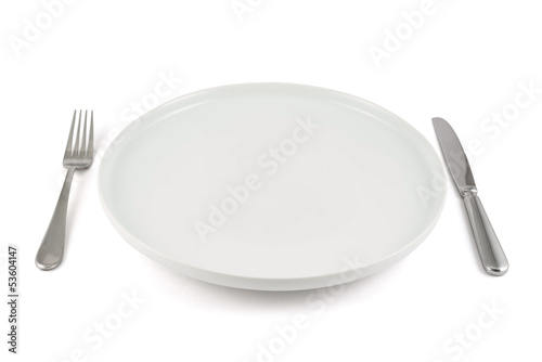 Table knife, fork and ceramic plate isolated