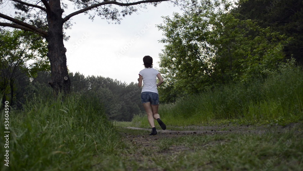 Young woman runs through forest and stops Young woman runs through forest and stops