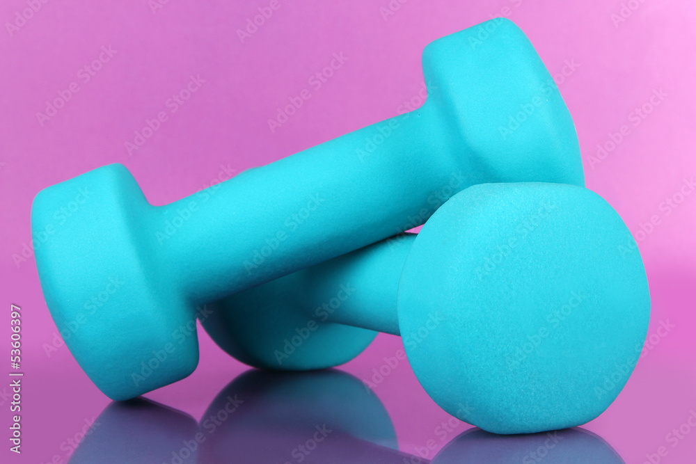 Dumbbells on purple background Dumbbells on purple background