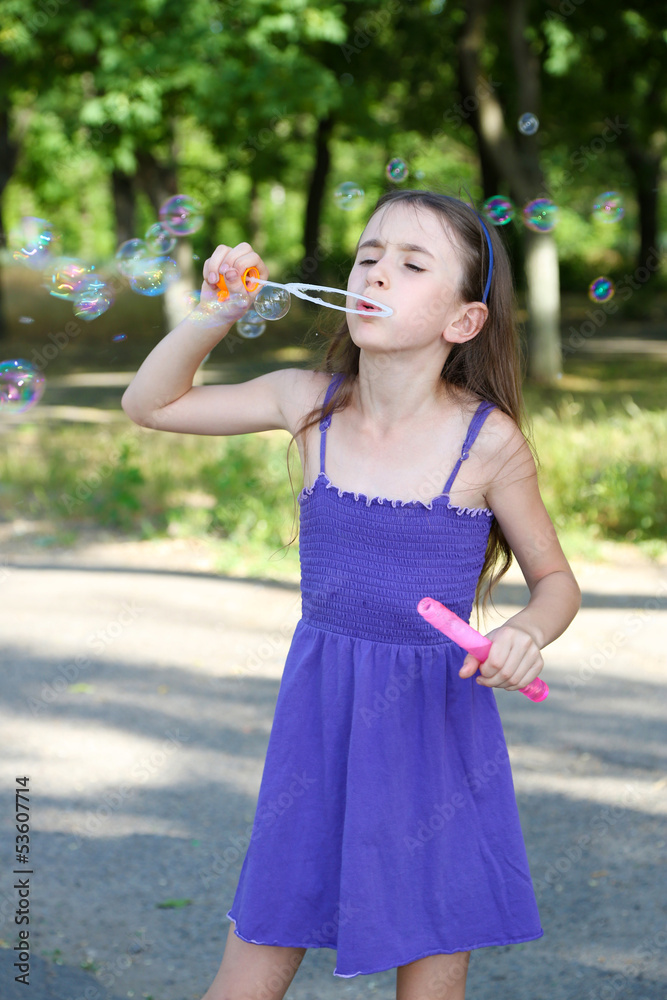 Cute girl blowing soap bubbles outdoors Cute girl blowing soap bubbles outdoors