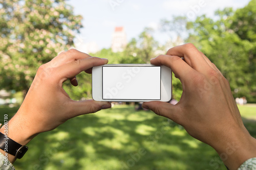 Man using mobile phone in the park as camera