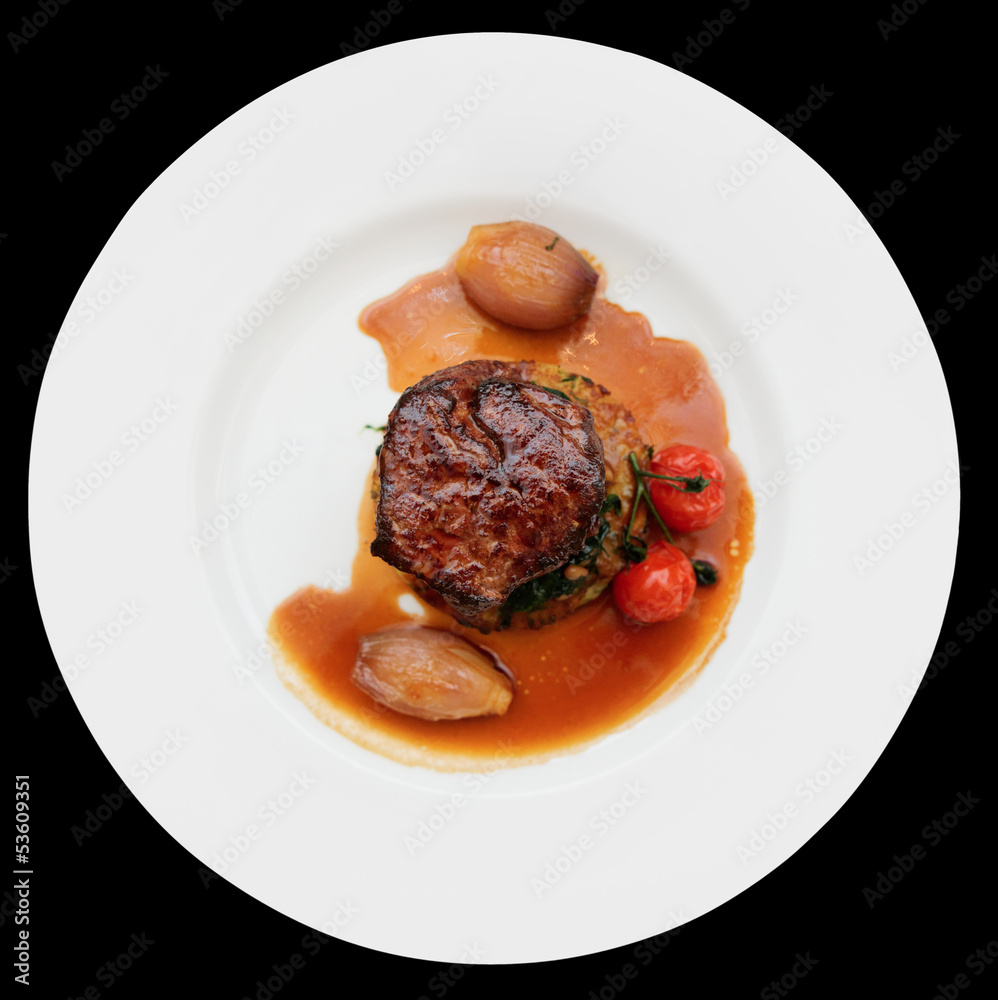 Tenderloin steak in plate, isolated on black Tenderloin steak in plate, isolated on black