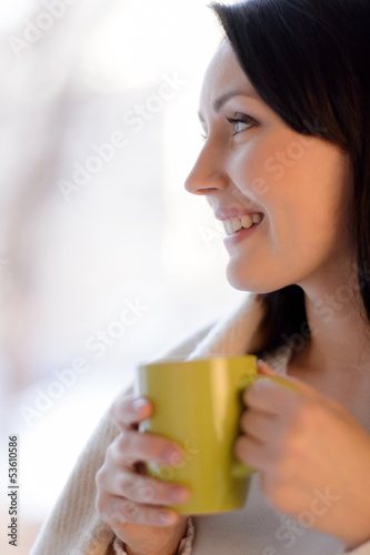 Woman drinking coffee. Beautiful middle-aged woman standing in f